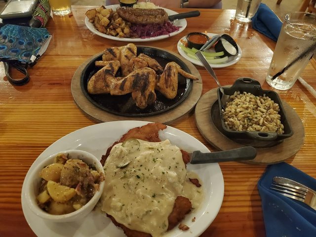 Texas Schnitzel with German Potato Salad, Spätzle, Grilled Chicken Wings in Center.