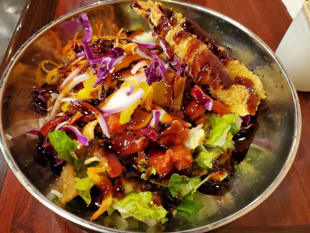 Poke bowl with spicy tuna and tempura shrimp. Cabbage, salad / rice mix, crab salad.